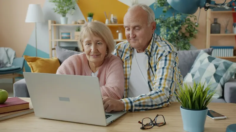 Älteres Paar schaut gemeinsam auf einen Laptop